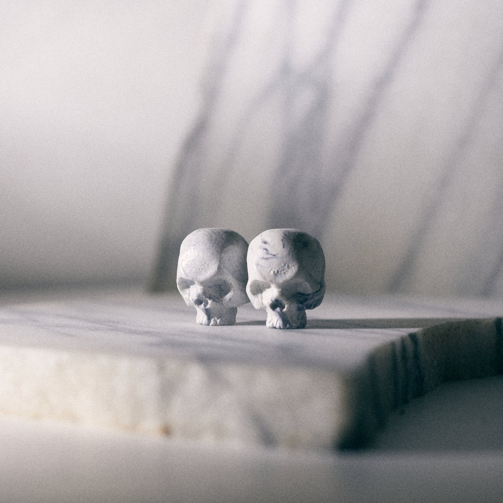 skull pins on carrara marble background