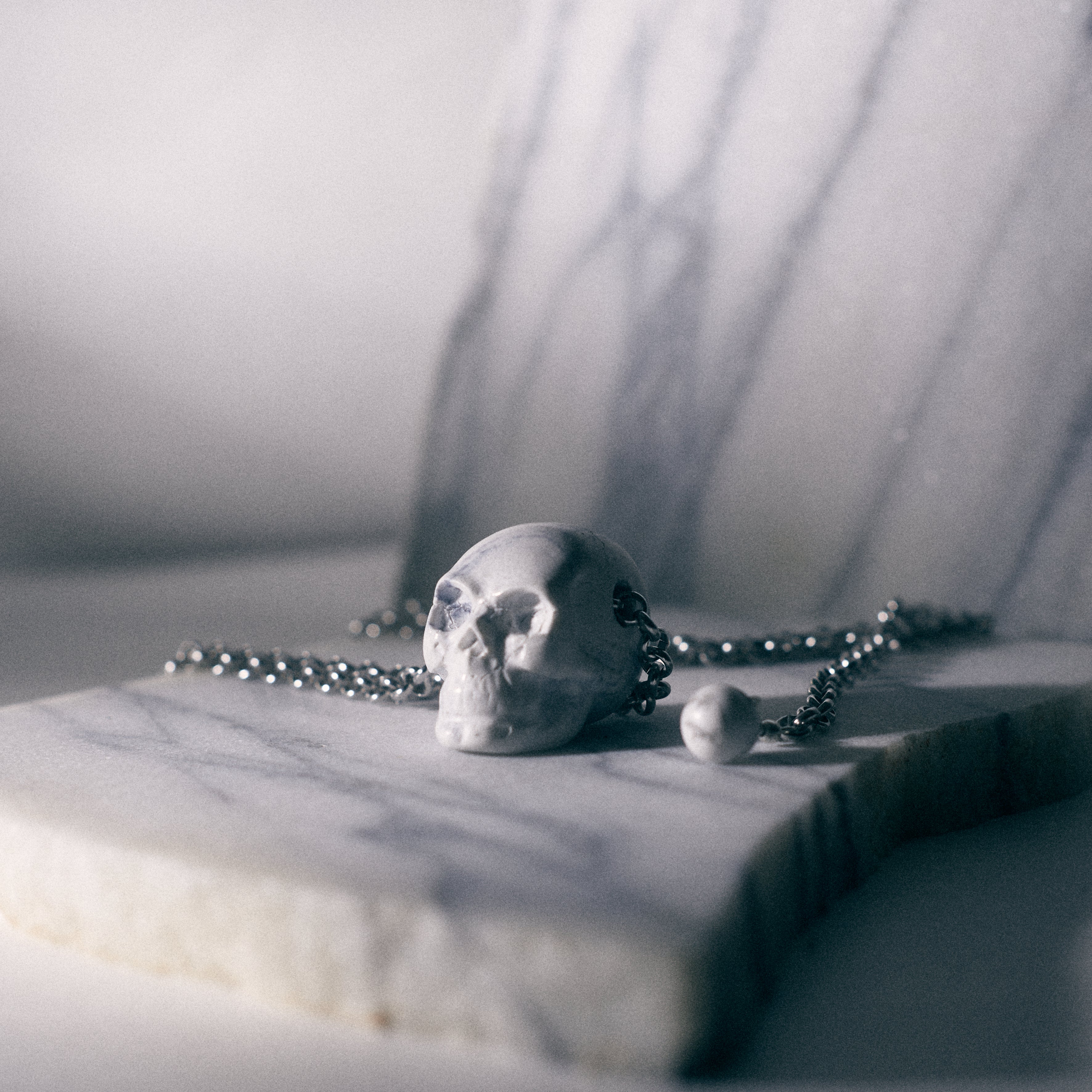 skull pendant mini sculture over carrara marble background