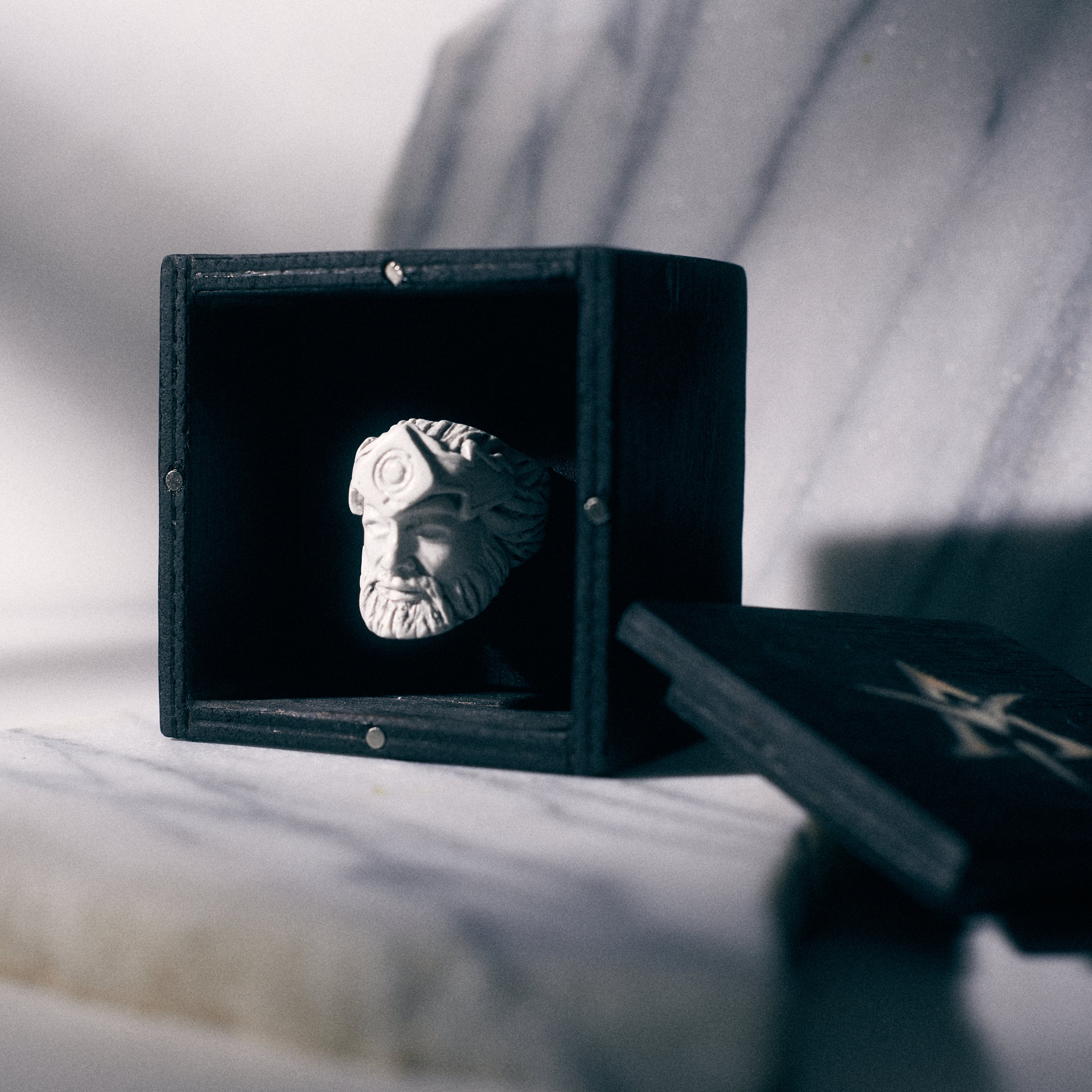 Sun god Bonded Marble Ring on yakisugi wood box over carrara marble